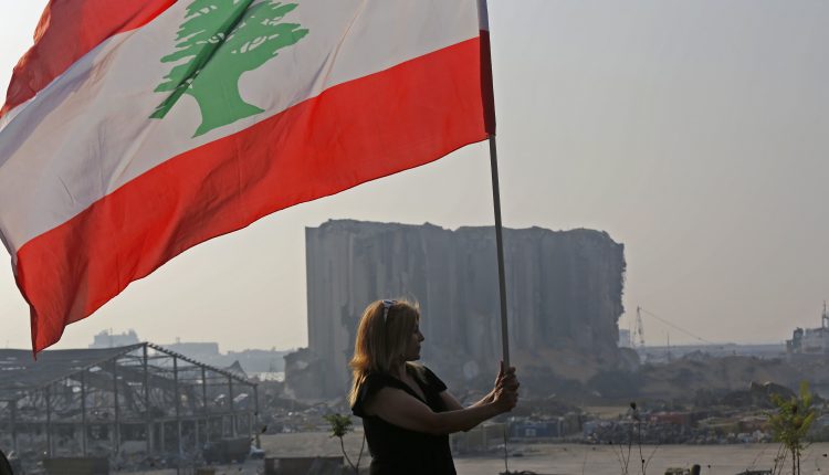 A-woman-holds-a-Lebanese-national-flag-750x430